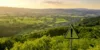 Blick über grüne Landschaft mit Schild Warnung im Vordergrund