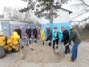 Eine Gruppe von Menschen mit Schaufeln vor einem Haufen Erde